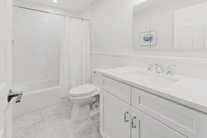 Een moderne badkamer met toilet, wastafel en douche.