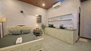 Un dormitorio con cama, mesita de noche, lámpara y una pequeña planta en maceta.