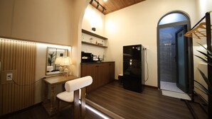 Una cocina compacta con armarios de madera, un refrigerador, un lavamanos y un espejo sobre el tocador.