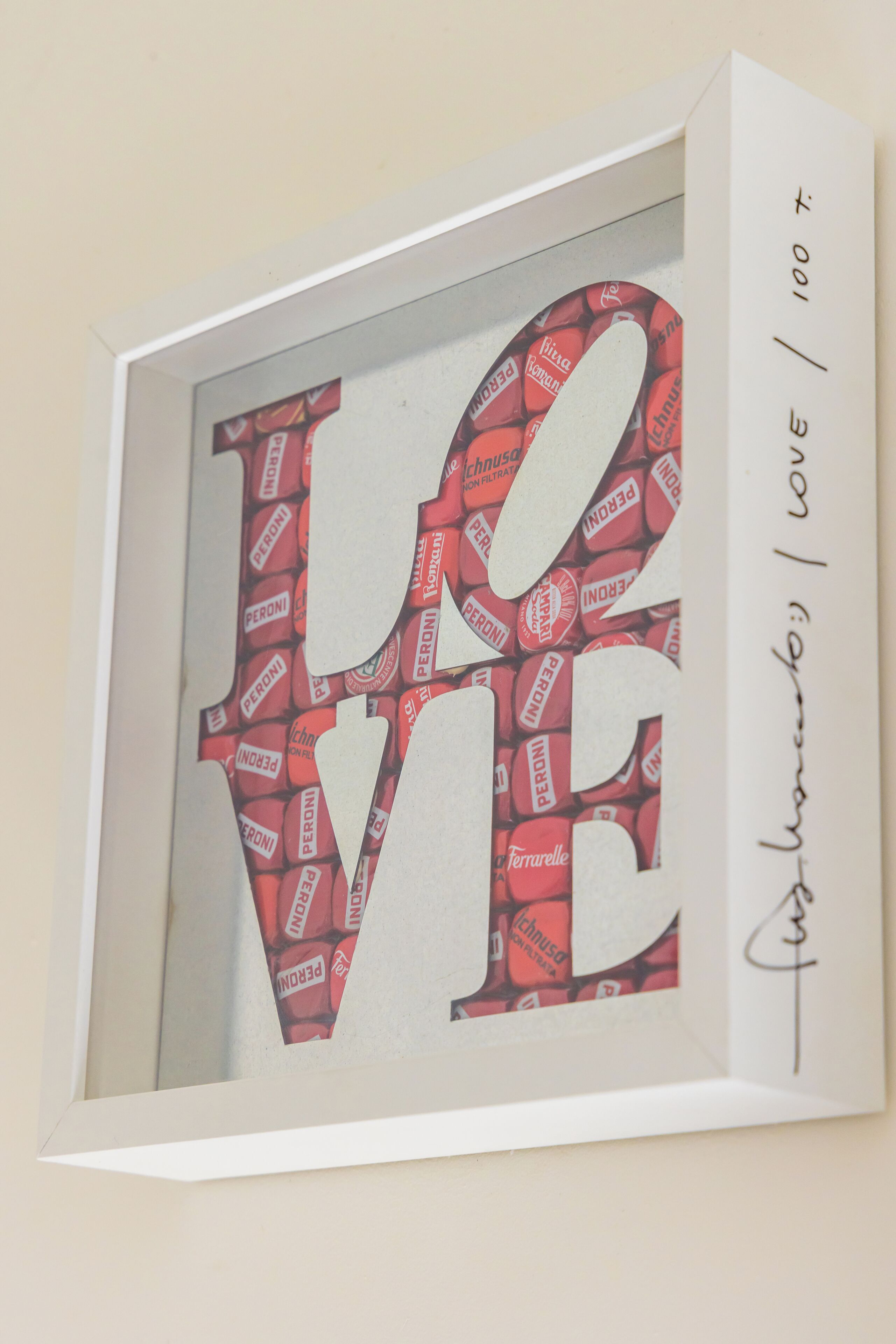 A framed artwork with the word 'LOVE' and a signature.