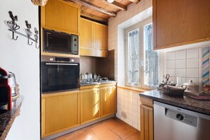 A kitchen with wooden cabinets, a microwave, an oven, and a dishwasher. - La Corte Dei Limoni - Countryside Retreat with Mountain View, Wi-Fi & Air Conditioning (Nocchi)