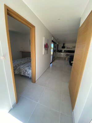 Ein modernes Interieur mit einem Flur, der zu einem Schlafzimmer und einer Küchenzeile führt.