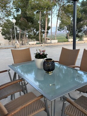A glass-top table with wicker chairs, a potted plant, and a decorative lantern. - La Pinada del Acueducto, ideal house to relax and rest. (Fortuna)