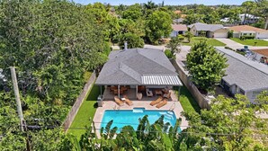 A residential property with a swimming pool, patio furniture, and a fenced yard. - The Full Florida Experience -Pool, Bikes and Beach (Naples)
