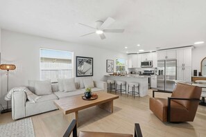 Ein modernes Wohnzimmer mit Sofa, Couchtisch und Essbereich.