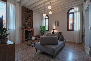 En stue med pejs, sofa og hængende lamper.