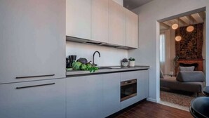 Una cocina moderna con horno empotrado, un lavamanos y una encimera con elementos decorativos.