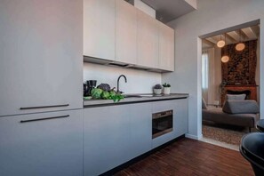 Une cuisine moderne équipée d’un four encastré, d’un évier et d’un plan de travail agrémenté d’objets décoratifs.