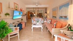 Un salon comprenant un téléviseur, un canapé, une table basse et des objets de décoration.