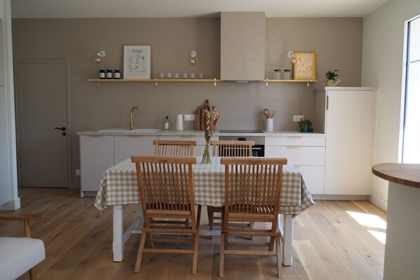 Une cuisine équipée d’une table à manger, de chaises et d’un réfrigérateur.