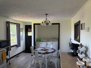 A kitchen with a dining table, chairs, a coffee machine, and a washing machine. - Fabulous 3-bedroom house with AC in charming Union (Union)