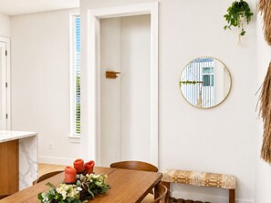 Ein Essbereich mit einem Holztisch, Kerzen und einer Blumenarrangemement.