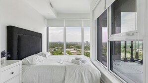 A bedroom with a large window, a bed, a nightstand, and a view of the city. - Stylish 2bed2bath| Parking | Gym | Sauna|4ppl (Toronto)