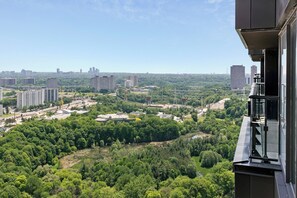 Ein Hochhaus mit Blick auf eine Stadtlandschaft und umliegende Grünflächen.