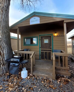 A small wooden cabin with a sign reading 'SMALL FRY 1,' a grill, and a propane tank.
