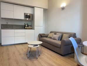 A modern kitchen with white cabinets, a microwave, and a kettle on the countertop. - Madama Apartment, new one-bedroom apartment, private parking, metro-city center. (Torino)