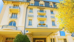 Ein mehrstöckiges Hotel mit Balkonen, einem überdachten Eingang und einer gepflegten Fassade.