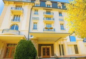 Ein mehrstöckiges Hotel mit Balkonen, einem überdachten Eingang und einer gepflegten Fassade.
