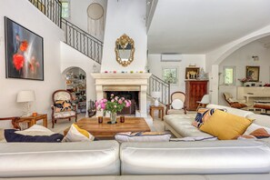 Ein geräumiges Wohnzimmer mit Kamin, Treppe und Essbereich.