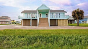 A two-story building with a balcony, a front entrance, and a small ramp leading to the main door. - The Seashell Suite Cozy 1BR Near the Beach (Bolivar Peninsula)