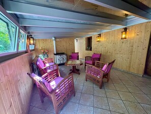 Ein Zimmer mit Holzwänden, einem Esstisch, Stühlen und einem Schrank.