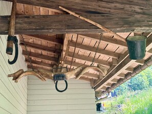 Un plafond en bois rustique, agrémenté d’un seau en métal suspendu et d’un crochet en bois.