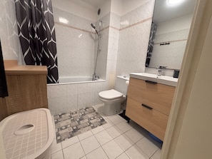 Un baño con bañera, inodoro, lavabo y ducha.