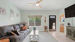 A living room with a grey sofa, a white coffee table, and a ceiling fan. - Happy Hound Poolside Retreat (Canyon Lake)
