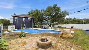A backyard with a swimming pool, a fire pit, and a house. - Happy Hound Poolside Retreat (Canyon Lake)