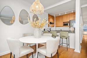 A modern kitchen with wooden cabinets, a white countertop, and a built-in microwave. - Portico 306 (Cape Town)