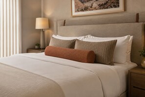 A neatly made bed with a headboard, a bedside lamp, and a framed picture on the wall. - Montvale Urban Suites (Toronto)