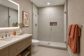 A modern bathroom with a shower, toilet, and vanity. - Montvale Urban Suites (Toronto)