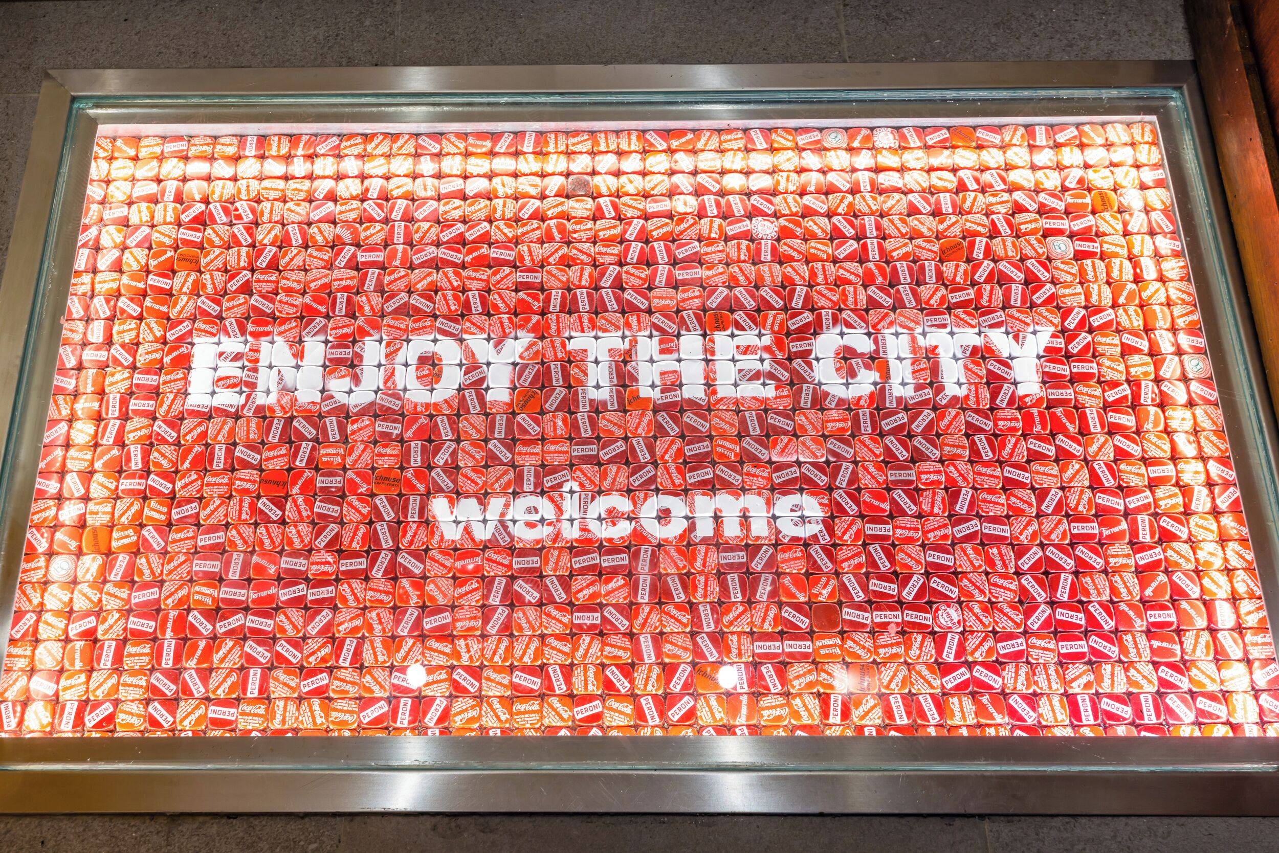A welcome sign with the text 'ENJOY THE CITY welcome' in a candy-themed display.