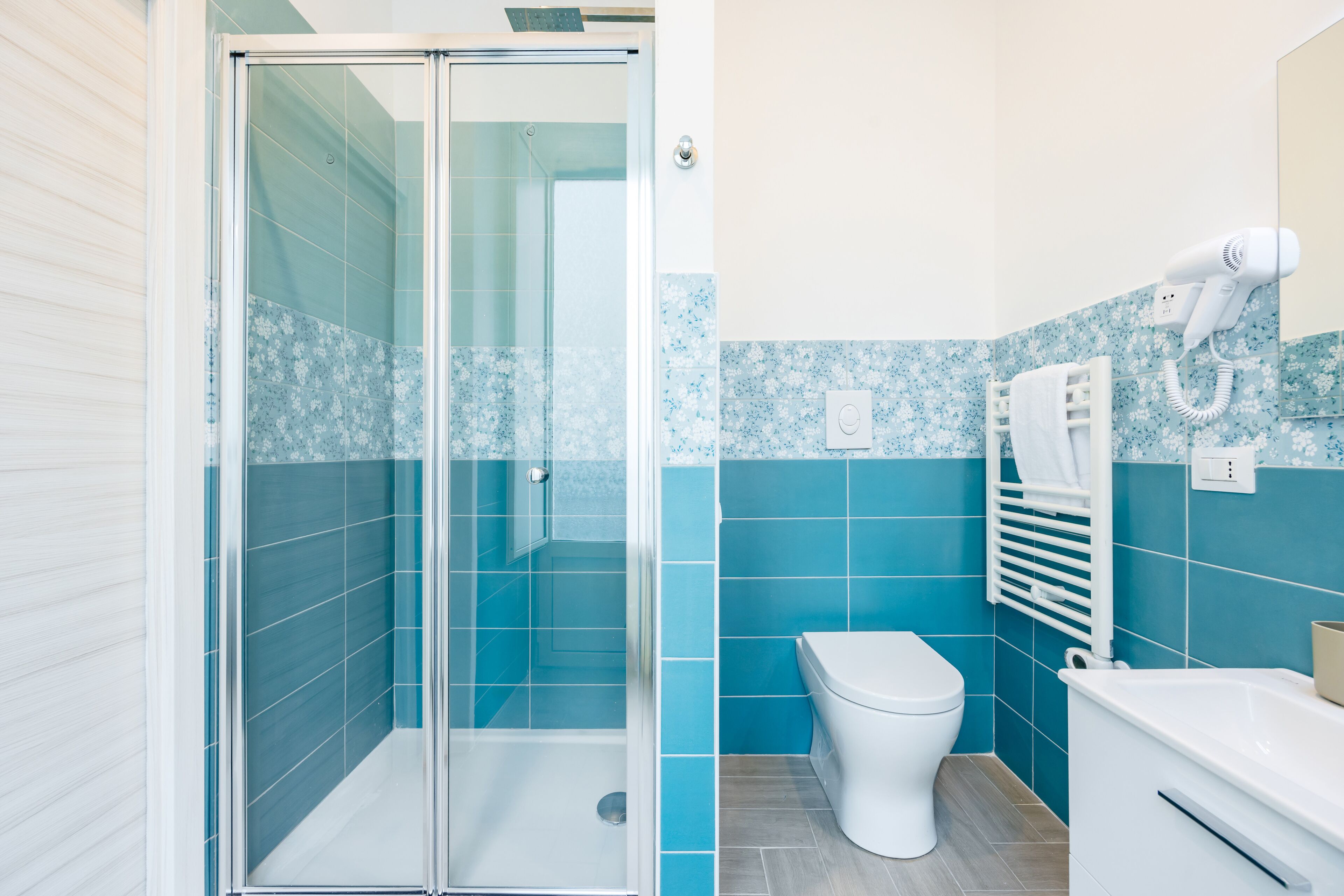 A bathroom with a glass shower enclosure, a white toilet, and a white bathtub.