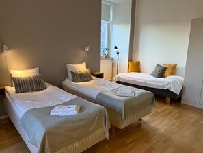 A room with two single beds, a standing lamp, and a window with a view. - Rindö Hamn Bed & Breakfast (Vaxholm)