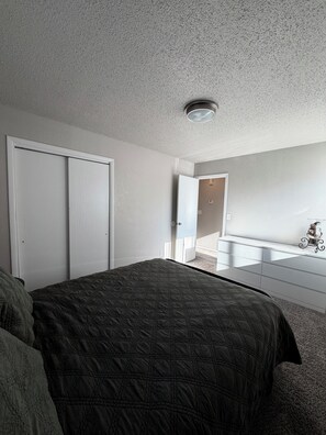 A bedroom with a bed, a dresser, and a closet. - The Workman’s Rest Pt. 2 No Cleaning Fee (Gillette)