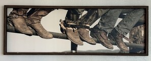 A framed photograph of multiple pairs of boots leaning against a metal pole. - The Workman’s Rest Pt. 2 No Cleaning Fee (Gillette)