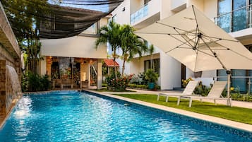 Una piscina al aire libre, sombrillas