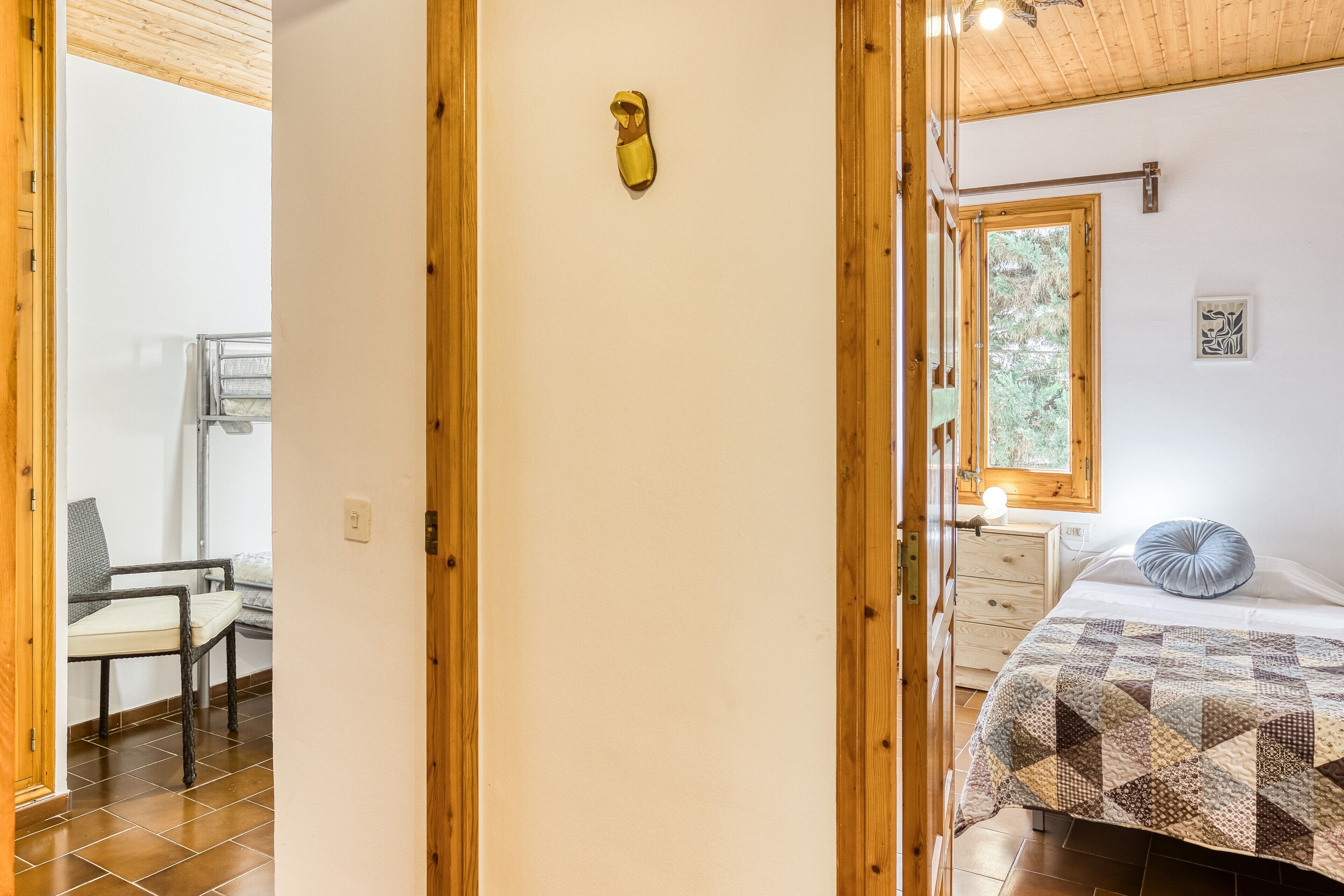 Une chambre à coucher avec un lit, une fenêtre, une chaise et une porte en bois.