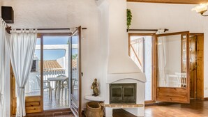 A room with a fireplace, a sliding glass door leading to an outdoor area, and a wooden floor.