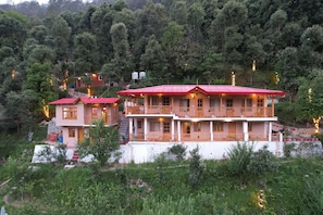 A two-story building with a red roof, multiple balconies, and a white exterior. - The Peach Hillside Kainchi Dham (Kosiyakutoli)