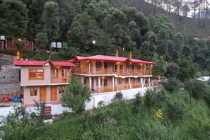 A two-story building with a red roof, multiple balconies, and a white exterior. - The Peach Hillside Kainchi Dham (Bhowali Gaon)