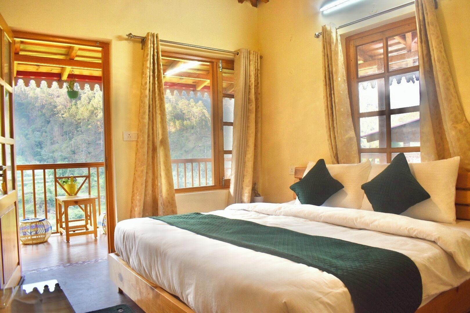A bedroom with a bed, curtains, and a view of the outdoors.
