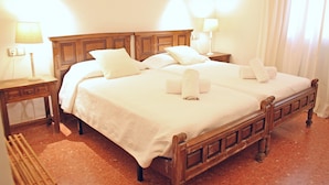Ein Doppelbett mit Holz-Kopfseitenverkleidung, zwei Nachttische mit Lampen und eine Sitzbank.
