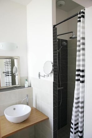 A bathroom with a white sink, mirror, and shower curtain.