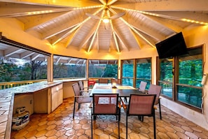 A modern kitchen with a large island, a dining area with a table and chairs, and large windows offering a view of the outdoors. - #1 Celebrity Mansion Estate Huge Dance Floor &  Pool Pickleball Secret Speakeasy (East Stroudsburg)