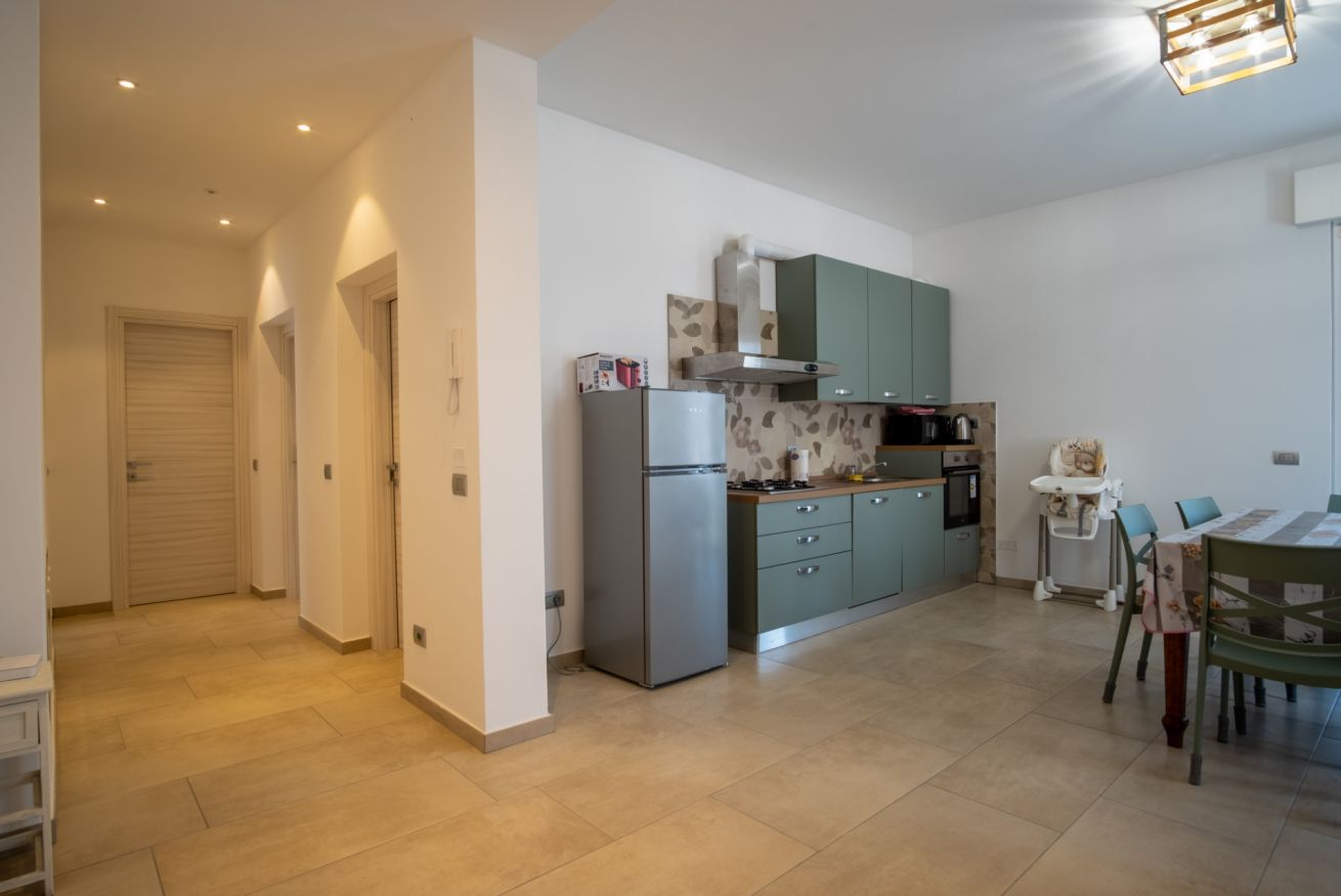 A modern kitchen with a refrigerator, stove, and dining area.