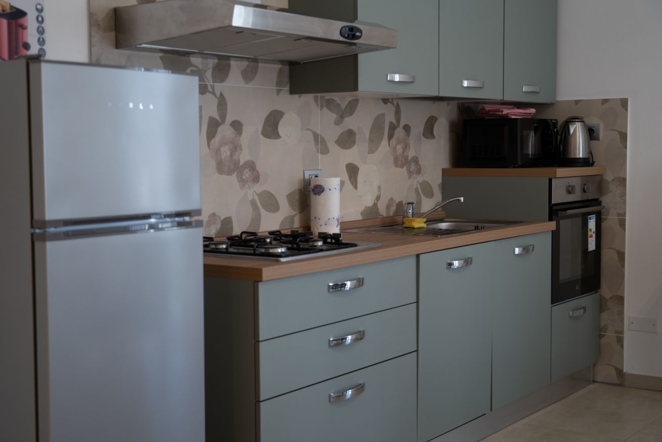 A kitchen with a refrigerator, stove, microwave, and cabinets.