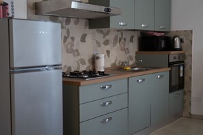 A kitchen with a refrigerator, stove, microwave, and cabinets. - A cozy 100 square meters apartment, perfect for six people, located on the first floor of a building without an elevator.The property is located in Quarto, a small village in the municipality of Gossolengo. The location is ideal for those seeking a relax (Quarto)