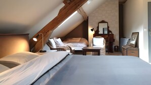 A bedroom with a sloped ceiling, a bed, a chair, a small table, a dresser, and a mirror. - Guest Room 'La Fosse Bleue, Sanglier' with Shared Terrace and Wi-Fi (Signy-l'Abbaye)